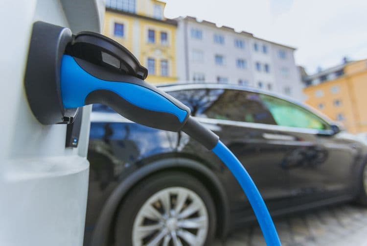 Elektro-Dienstwagen korrekt abrechnen: Vorteile für Arbeitgeber und Mitarbeitende Elektroauto lädt an einer Ladesäule in der Stadt – Symbol für geldwerten Vorteil durch Firmenfahrzeuge