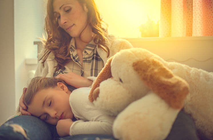 Mutter mit Kind – Symbolbild für Elternzeit und Lohnabrechnung in der Lohnbuchhaltung Eine Mutter sitzt mit ihrem schlafenden Kind auf dem Schoß und hält es schützend im Arm – ein Symbolbild für Mutterschutz, Elterngeld und familienbedingte Abwesenheiten in der Lohnbuchhaltung