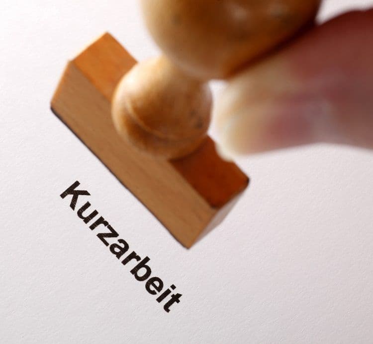 Stempel mit dem Wort Kurzarbeit – Relevanz für die Lohnbuchhaltung und Abrechnung Ein Holzstempel mit der Aufschrift „Kurzarbeit“ wird auf ein Papier gedrückt – Symbolbild für die Auswirkungen von Kurzarbeit auf die Lohnabrechnung